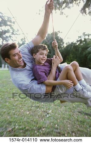 Side profile of a father and son swinging on a rope swing View Large Photo Image Stock Image - Side profile of a father and son swinging on a rope swing. Fotosearch