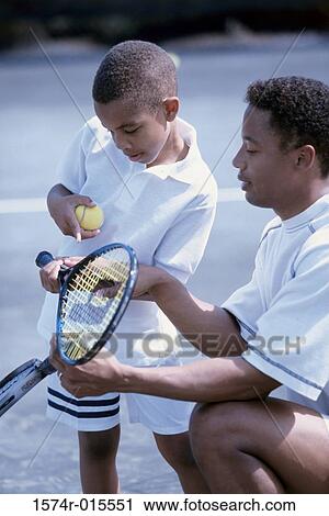 Side profile of a father teaching his son to play tennis View Large Photo Image Stock Image - Side profile of a father teaching his son to play tennis. Fotosearch