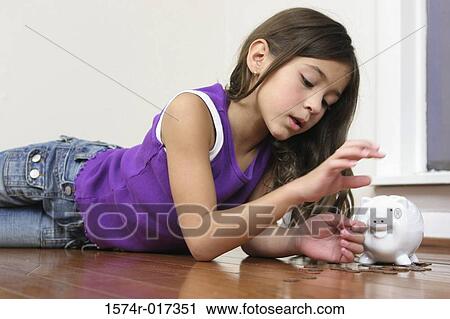 Side profile of a girl lying on the floor with a piggy bank beside her View Large Photo Image Stock Image - Side profile of a girl lying on the floor with a piggy bank beside her. Fotosearch