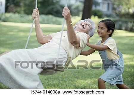 Side profile of a granddaughter pushing her grandmother on a swing View Large Photo Image Stock Image - Side profile of a granddaughter pushing her grandmother on a swing. Fotosearch