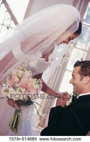 Stock Photography - Side profile of a groom proposing to his bride. Fotosearch