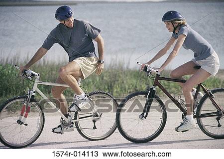 Side profile of a mature couple cycling on the road View Large Photo Image Stock Image - Side profile of a mature couple cycling on the road. Fotosearch