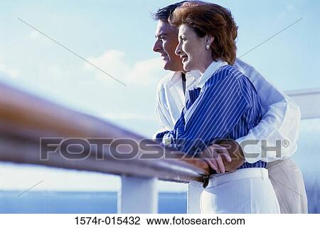 Side profile of a mature couple standing on the deck of a cruise ship View Large Photo Image Stock Image - Side profile of a mature couple standing on the deck of a cruise ship. Fotosearch