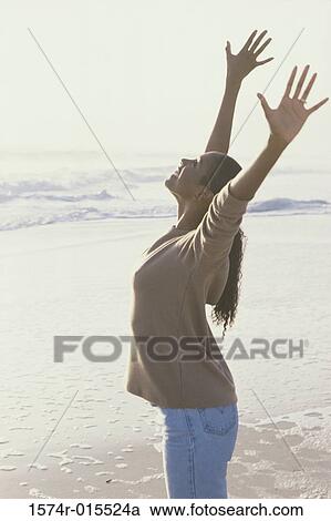 Side profile of a mid adult woman standing with her arms raised View Large Photo Image Stock Image - Side profile of a mid adult woman standing with her arms raised. Fotosearch