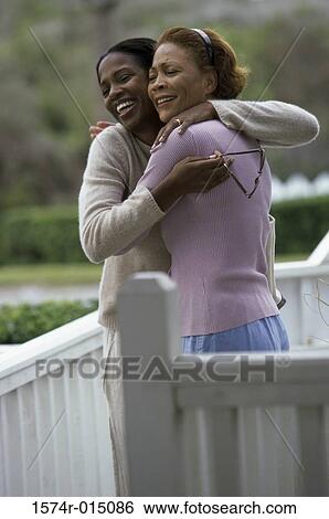Stock Photograph - Side profile of a mother hugging her daughter. Fotosearch