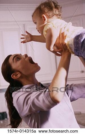 Stock Image - Side profile of a mother lifting her daughter. Fotosearch