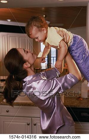 Stock Photograph - Side profile of a mother lifting her daughter. Fotosearch