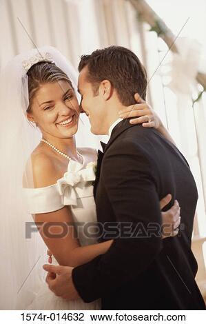 Side profile of a newlywed couple embracing each other View Large Photo Image Stock Image - Side profile of a newlywed couple embracing each other. Fotosearch