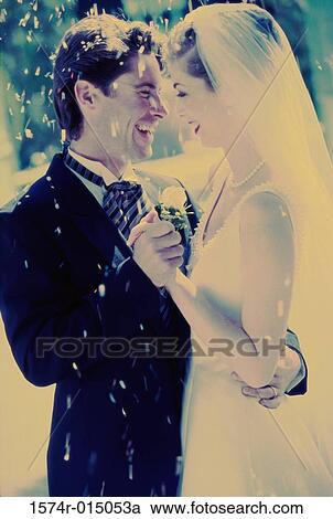Stock Image - Side profile of a newlywed couple dancing. Fotosearch