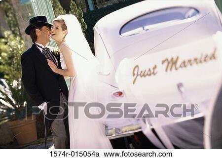 Side profile of a newlywed couple standing beside a car View Large Photo Image Stock Image - Side profile of a newlywed couple standing beside a car. Fotosearch