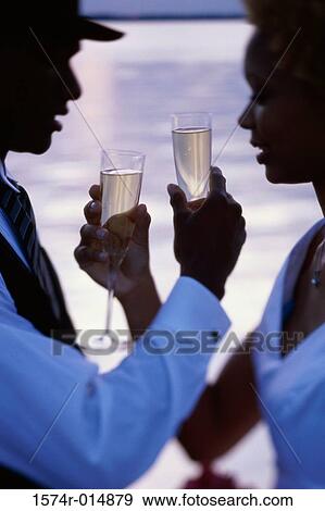 Side profile of a newlywed couple holding champagne flutes View Large Photo Image Stock Photo - Side profile of a newlywed couple holding champagne flutes. Fotosearch