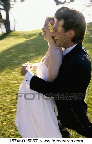 Stock Photo - Side profile of a newlywed couple laughing. Fotosearch