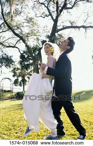 Stock Photo - Side profile of a newlywed couple laughing. Fotosearch