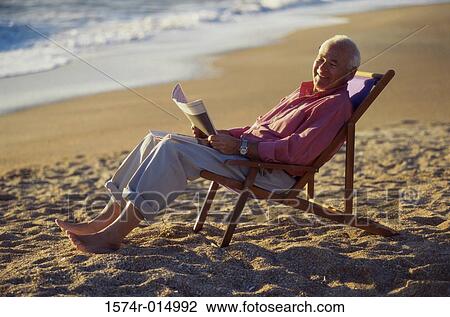 Side profile of a senior man holding a newspaper on the beach View Large Photo Image Stock Image - Side profile of a senior man holding a newspaper on the beach. Fotosearch