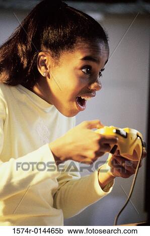 Side profile of a teenage girl playing video games View Large Photo Image Stock Image - Side profile of a teenage girl playing video games. Fotosearch