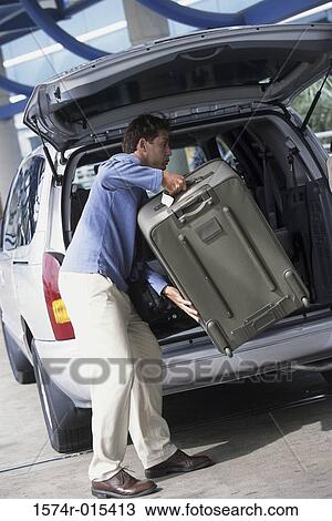 Side profile of a young man loading luggage into the back of a car View Large Photo Image Stock Image - Side profile of a young man loading luggage into the back of a car. Fotosearch