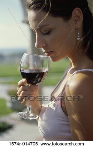 Stock Photography - Side profile of a young woman drinking wine. Fotosearch