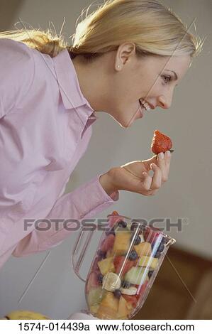 Side profile of a young woman eating a strawberry View Large Photo Image Stock Image - Side profile of a young woman eating a strawberry. Fotosearch