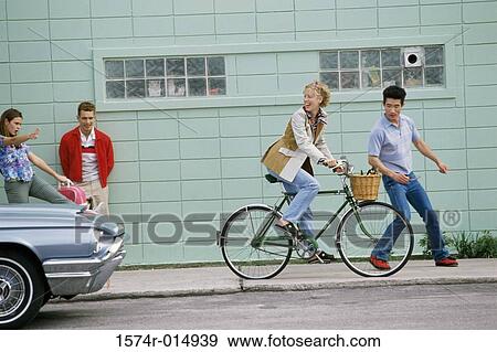 Stock Photo - Side profile of a young woman riding a bicycle and looking back. Fotosearch