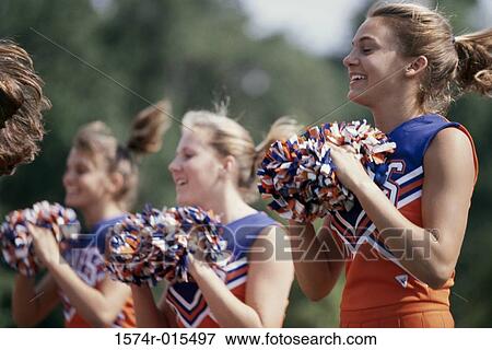 Side profile of three cheerleaders holding pom-poms View Large Photo Image Stock Photo - Side profile of three cheerleaders holding pom-poms. Fotosearch