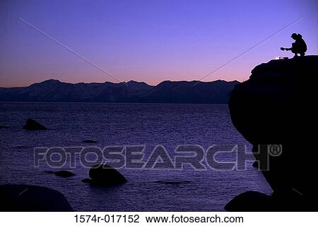 Silhouette of a hiker crouching at the edge of a rock View Large Photo Image Stock Image - Silhouette of a hiker crouching at the edge of a rock. Fotosearch