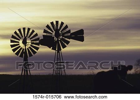 Silhouette of two windmills in a field View Large Photo Image Stock Photograph - Silhouette of two windmills in a field. Fotosearch