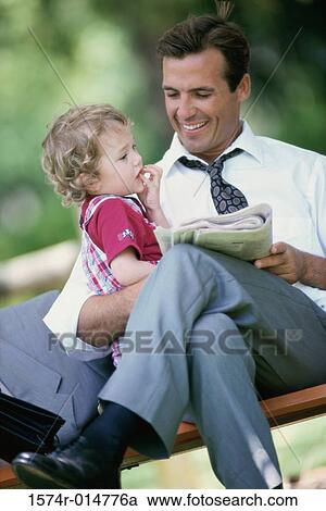 Son sitting on his father's lap View Large Photo Image Stock Image - Son sitting on his father's lap. Fotosearch