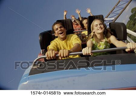 Stock Image - Teenage couple riding a rollercoaster. Fotosearch