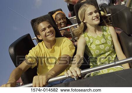 Teenage couple riding a rollercoaster View Large Photo Image Stock Image - Teenage couple riding a rollercoaster. Fotosearch