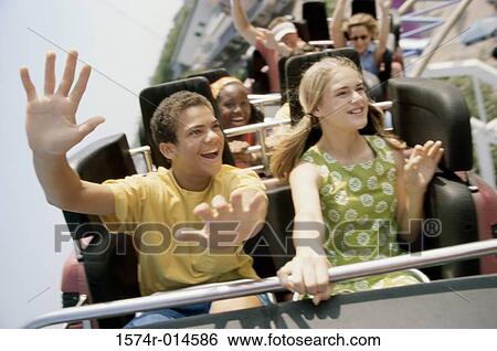 Stock Photograph - Teenage couple riding a rollercoaster. Fotosearch