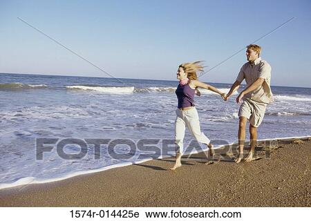 Teenage girl running with a young man on the beach View Large Photo Image Stock Image - Teenage girl running with a young man on the beach. Fotosearch