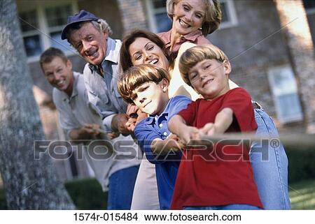 Three generation family playing tug-of-war in the backyard View Large Photo Image Picture - Three generation family playing tug-of-war in the backyard. Fotosearch