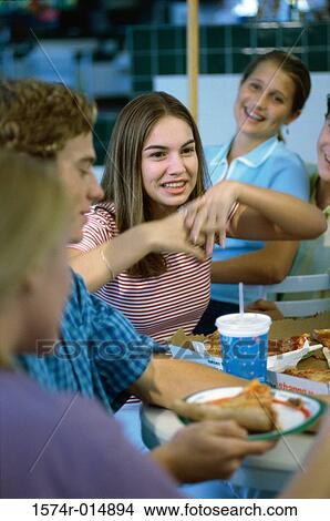 Three teenage girls and a teenage boy smiling in a restaurant View Large Photo Image Picture - Three teenage girls and a teenage boy smiling in a restaurant. Fotosearch