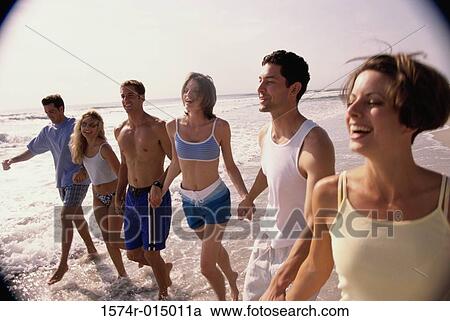 Three young couples holding hands walking on the beach View Large Photo Image Stock Image - Three young couples holding hands walking on the beach. Fotosearch