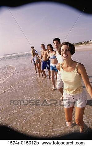 Three young couples holding hands walking on the beach View Large Photo Image Stock Image - Three young couples holding hands walking on the beach. Fotosearch