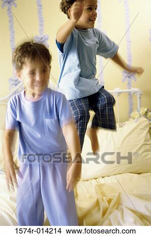 Two boys jumping on the bed View Large Photo Image Picture - Two boys jumping on the bed. Fotosearch