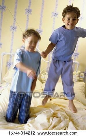 Two boys jumping on the bed View Large Photo Image Stock Image - Two boys jumping on the bed. Fotosearch