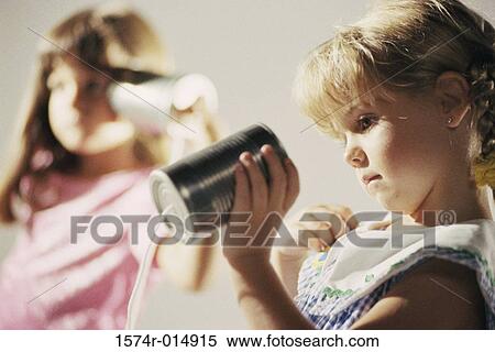 Two girls playing with a tin can phone View Large Photo Image Stock Photography - Two girls playing with a tin can phone. Fotosearch