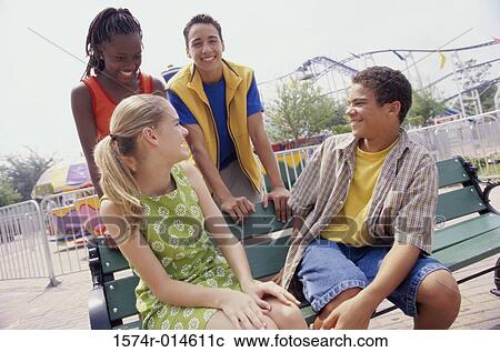 Stock Image - Two teenage boys and two teenage girls smiling. Fotosearch