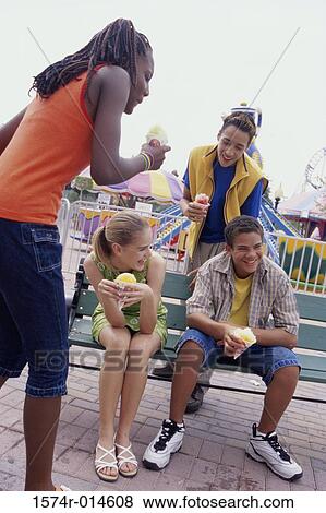 Two teenage boys and two teenage girls eating ice cream cones View Large Photo Image Stock Photo - Two teenage boys and two teenage girls eating ice cream cones. Fotosearch