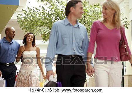 Two young couples carrying shopping bags View Large Photo Image Stock Image - Two young couples carrying shopping bags. Fotosearch