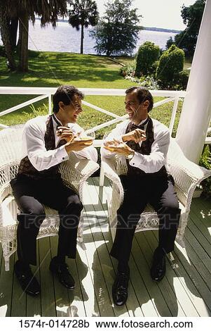 Stock Image - Two young men sitting together. Fotosearch