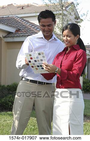 Stock Photo - Young couple choosing color from a color swatch. Fotosearch