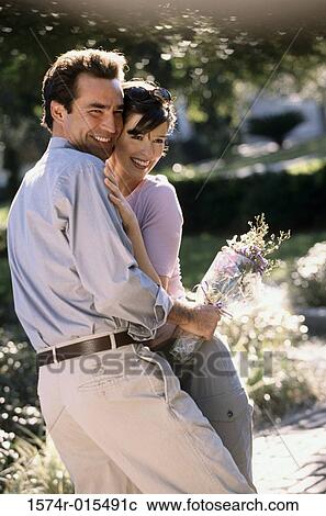 Stock Image - Young couple embracing each other and smiling. Fotosearch