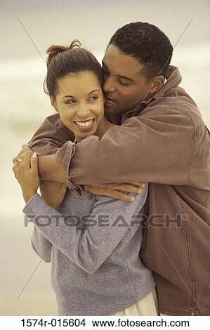 Picture - Young couple hugging on the beach. Fotosearch