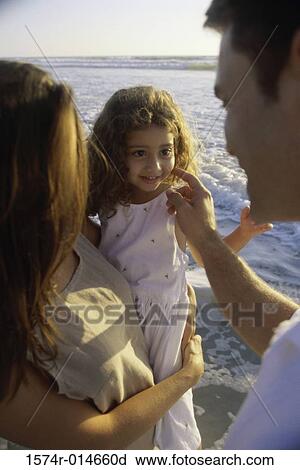 Young couple on the beach with their daughter View Large Photo Image Stock Image - Young couple on the beach with their daughter. Fotosearch