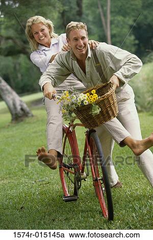 Young couple riding a bicycle View Large Photo Image Stock Image - Young couple riding a bicycle. Fotosearch