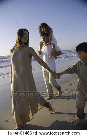 Young couple walking on the beach with their son and daughter View Large Photo Image Stock Image - Young couple walking on the beach with their son and daughter. Fotosearch