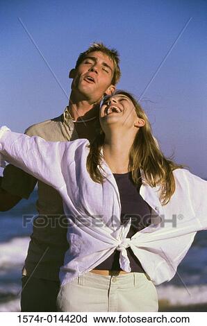 Young man and a teenage girl laughing on the beach View Large Photo Image Stock Image - Young man and a teenage girl laughing on the beach. Fotosearch