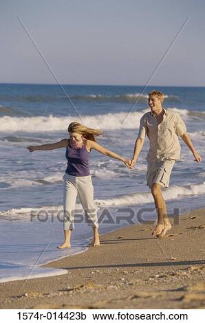 Young man and a teenage girl running on the beach View Large Photo Image Stock Image - Young man and a teenage girl running on the beach. Fotosearch